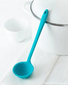 The Teal Skinny Ladle on a white towel on a white background. 